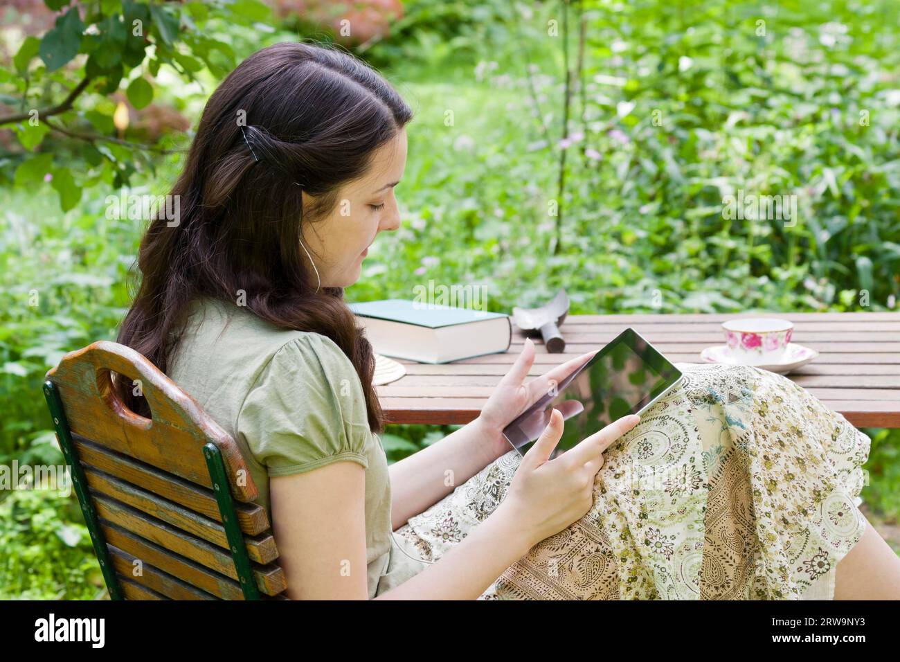 Junge Frau mit Tablet-PC im Garten, junge Frau mit Tablet-PC im Garten Stockfoto