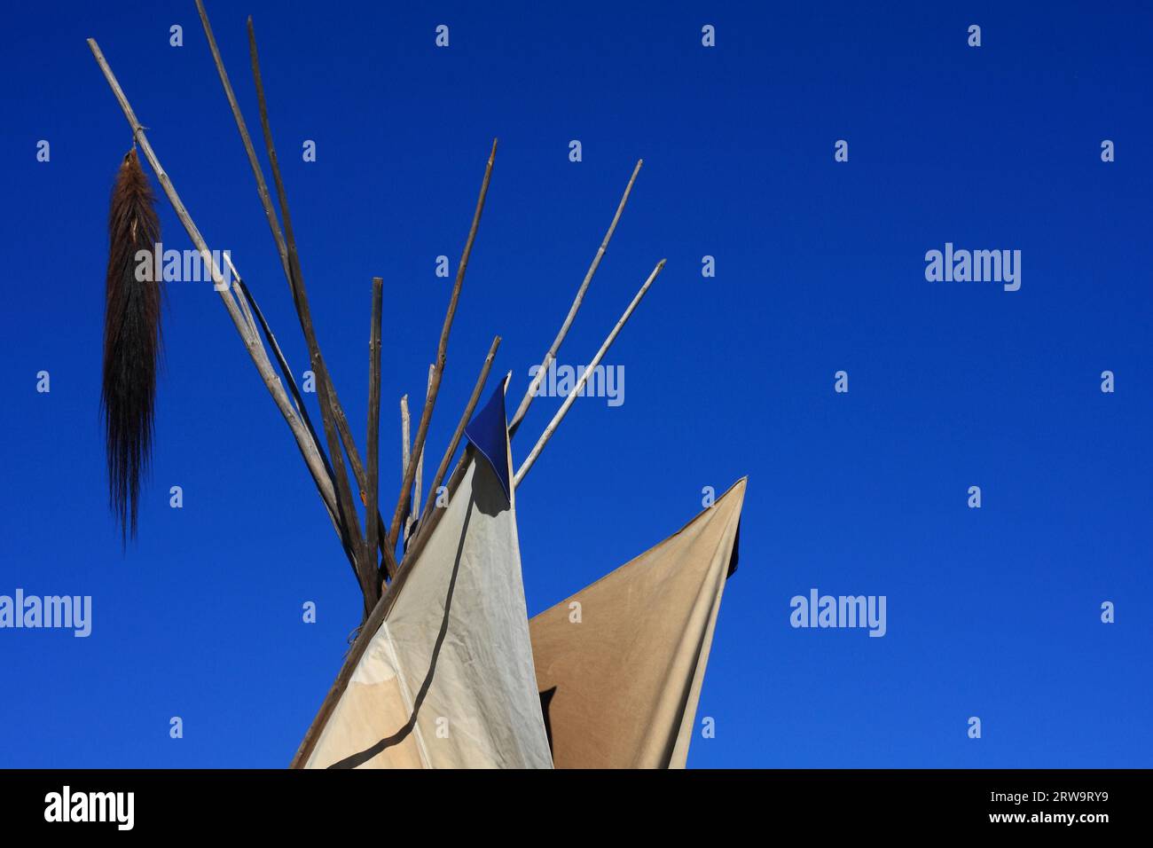 Weiß-braunes Indianerzelt mit Pferdeschwanz, blauer Himmel im Hintergrund Stockfoto