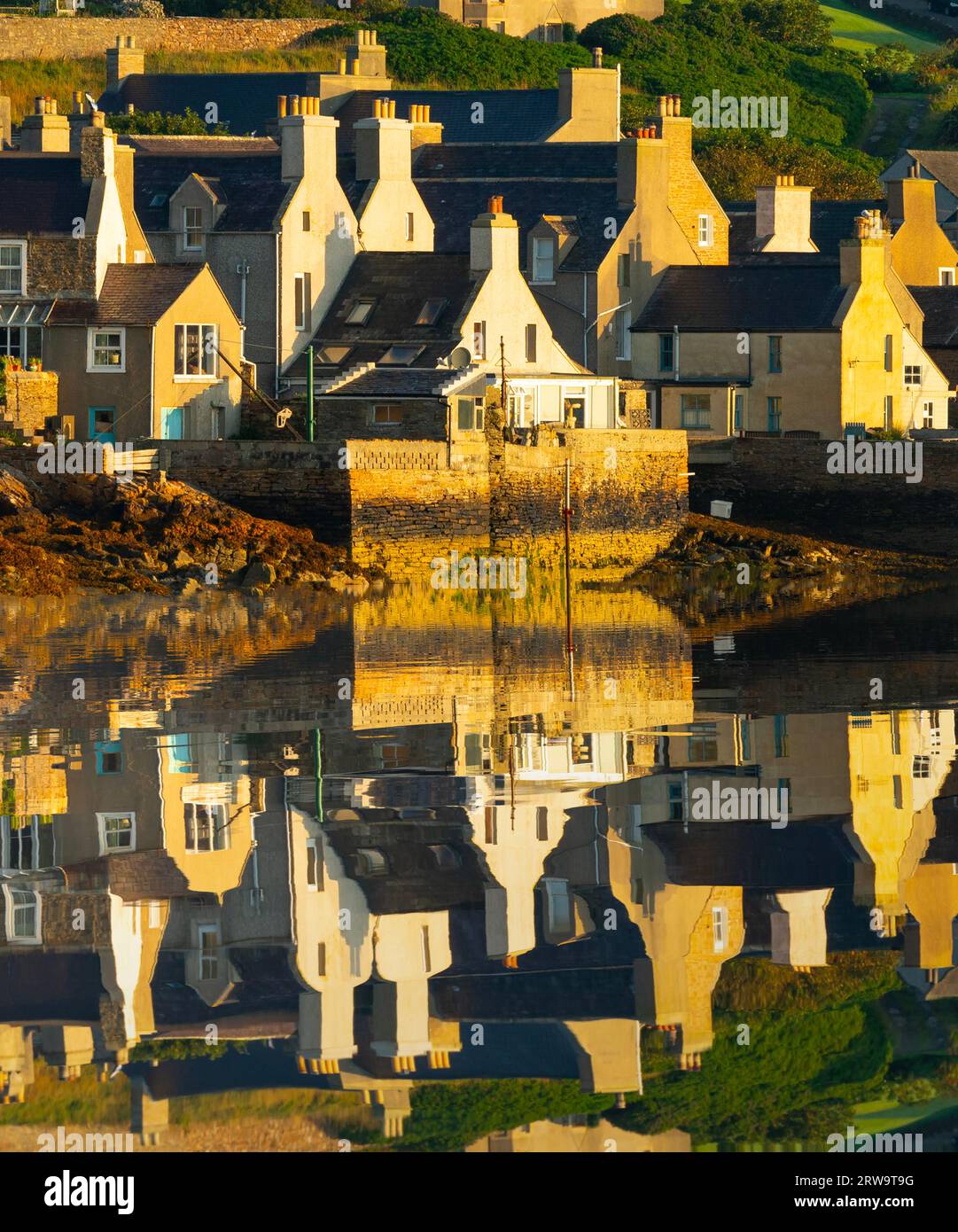 Am frühen Morgen Blick auf die Häuser in Stromness, die sich im Hafenwasser in Orkney Islands, Schottland, Großbritannien widerspiegeln Stockfoto