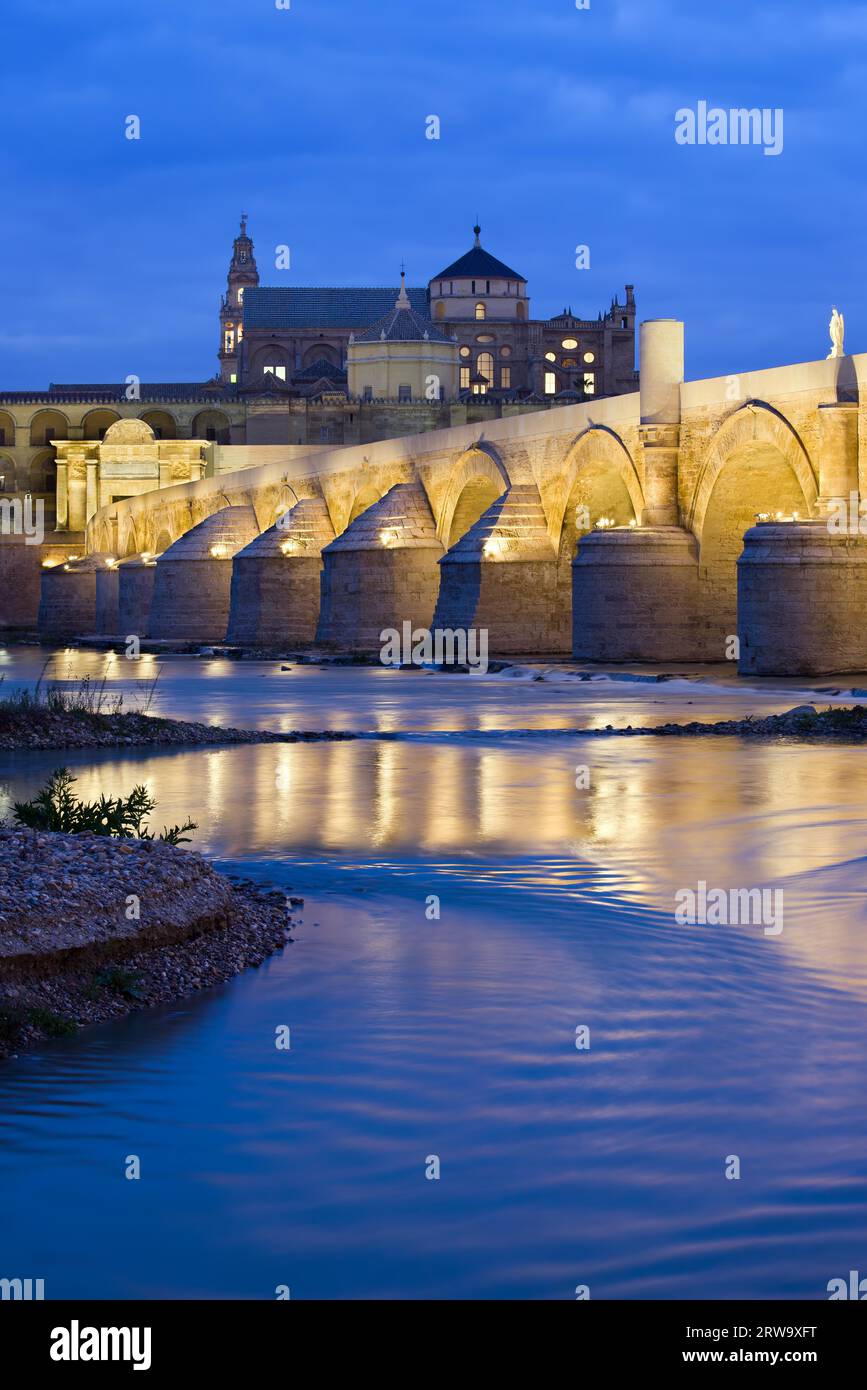 Römische Brücke auf dem Guadalquivir Fluss und die große Moschee (Mezquita Kathedrale) bei Tagesanbruch in der Stadt Cordoba, Andalusien, Spanien Stockfoto