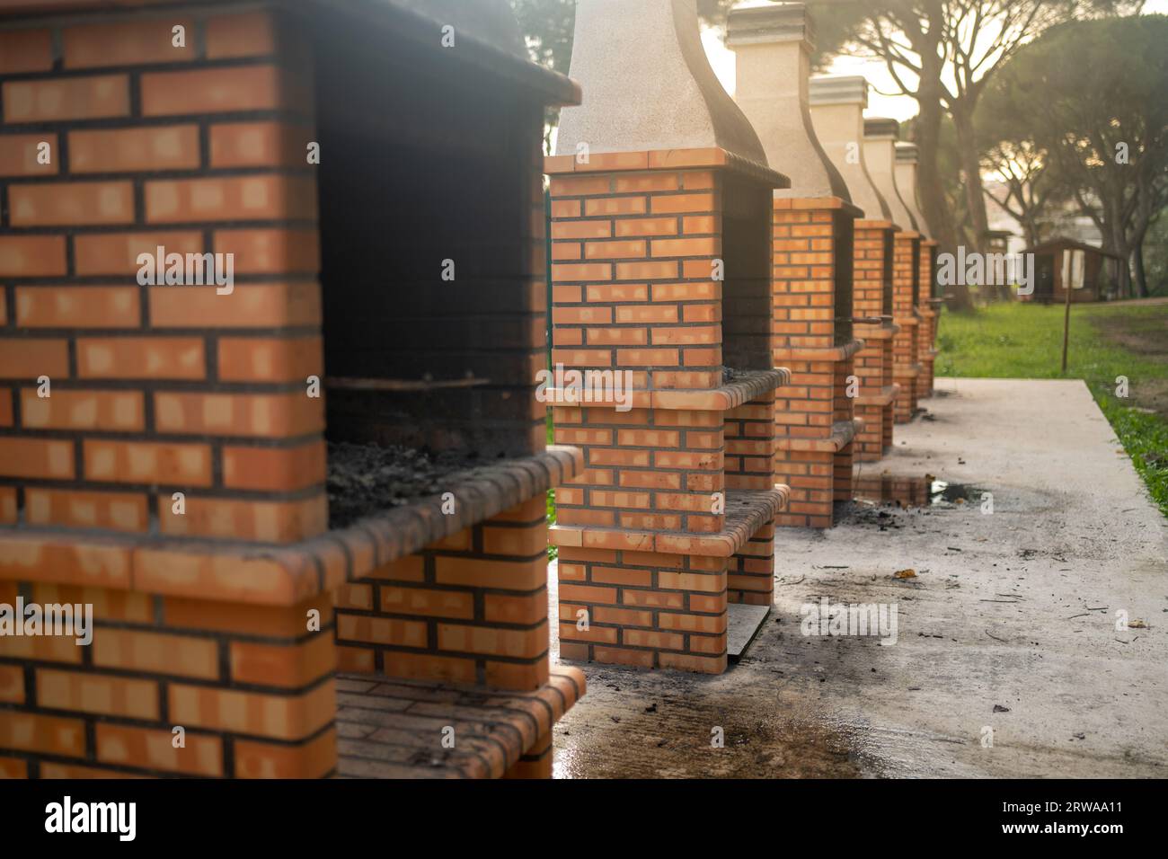 Öffentliches BBQ zum Kochen im Freien. Kochstruktur für den Außenbereich mit. Rote Backsteingrills aus solidem Fundament aus roten Ziegeln. Selektiver Fokus Stockfoto