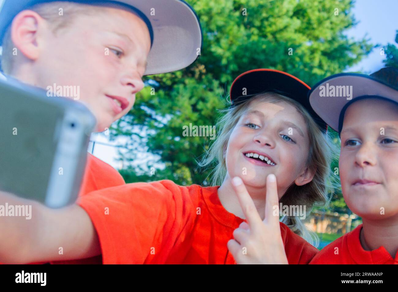 Ein 10-jähriges Mädchen, das mit einem Team im Baseball-Dugout auf der Jagd ist Stockfoto