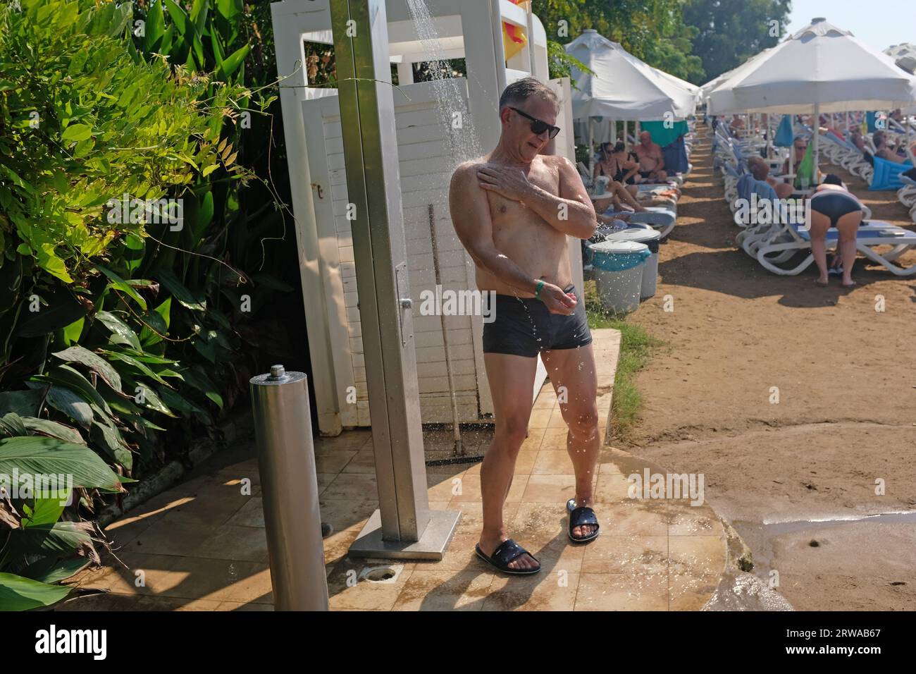 Ein Mann duscht am Strand in Side, Truthahn. Stockfoto