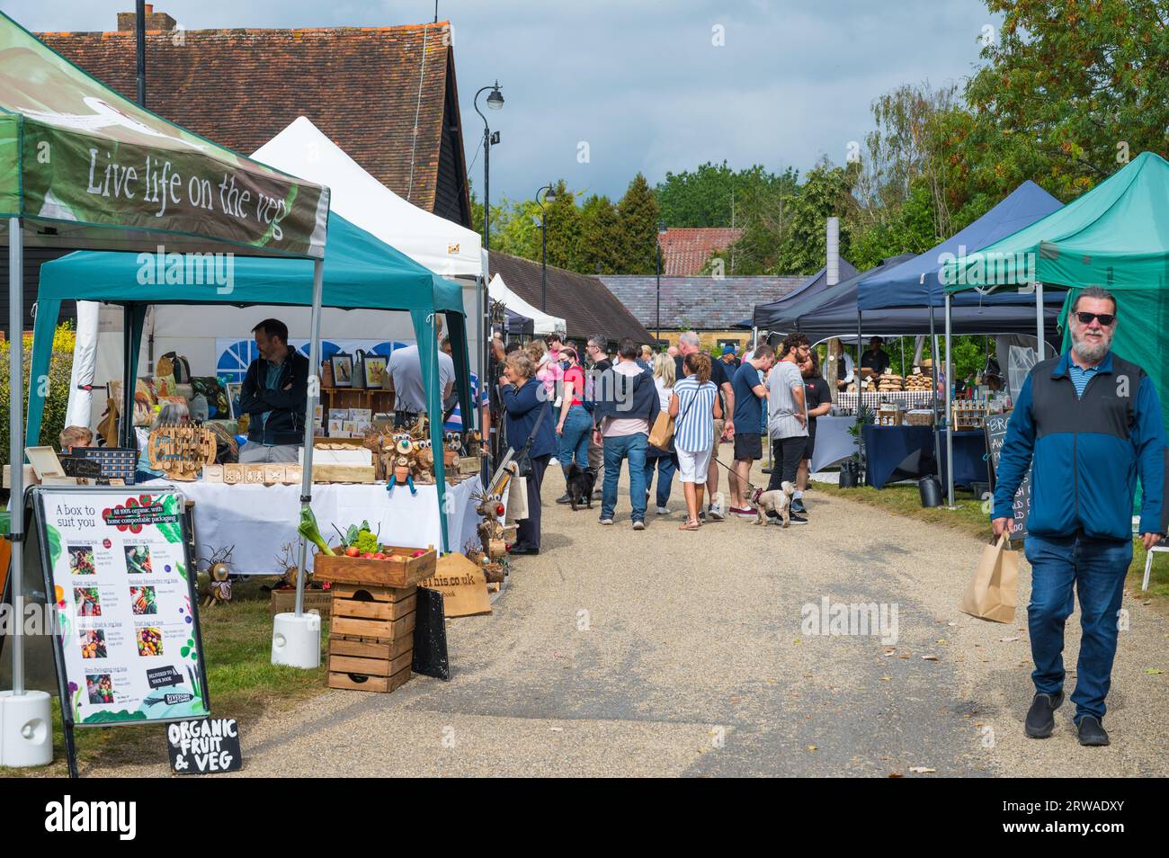 Besucher besuchen die Verkaufsstände am Duckpond Market, einem traditionellen Lebensmittel- und Kunsthandwerksmarkt, der monatlich auf der Manor Farm in Ruislip, Middlesex, England, Großbritannien stattfindet Stockfoto