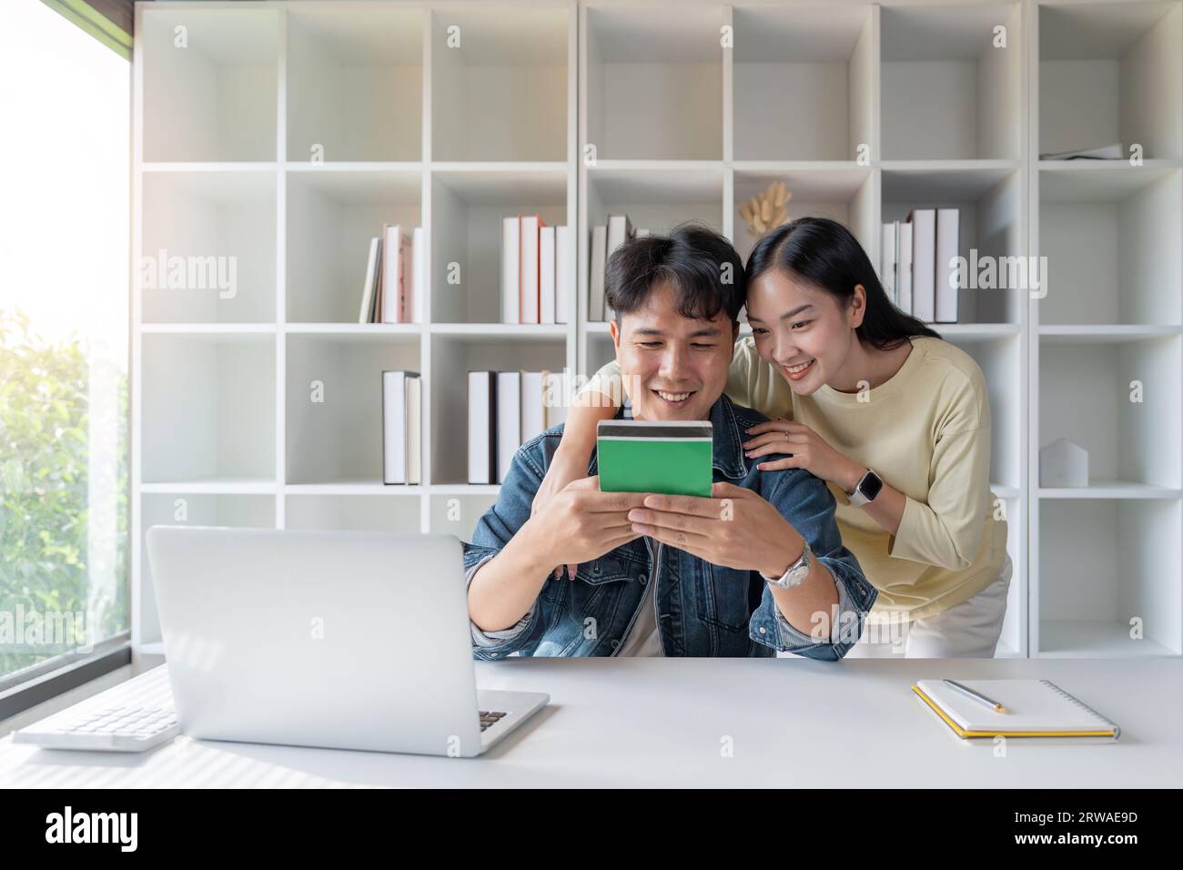 Glückliche asiatische Ehepaare schauen sich das Kontenbuch an, um Investitionen und Familienfinanzierung zu planen Stockfoto