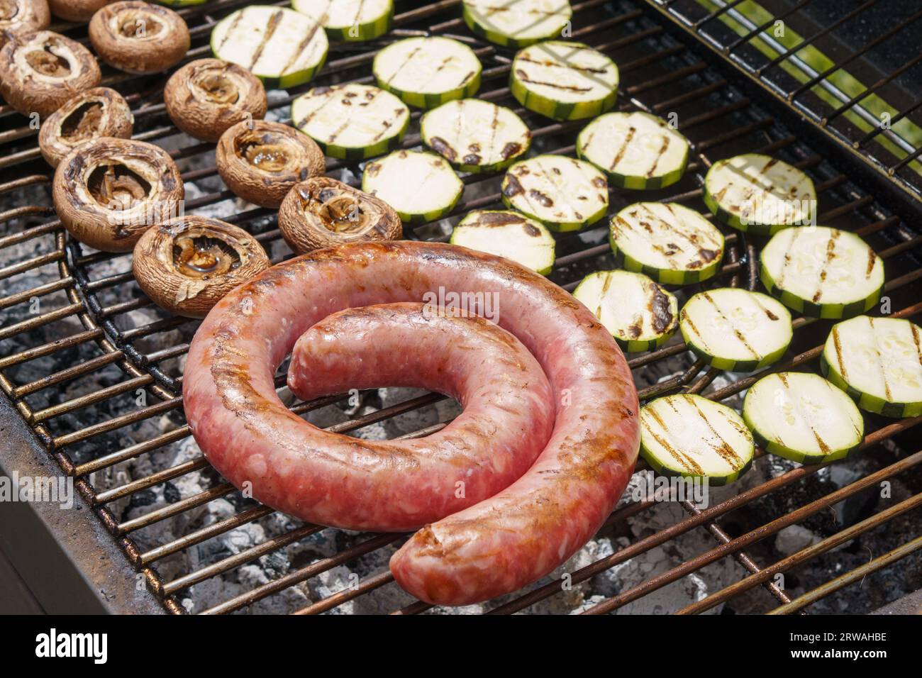 Barbecue mit Würstchen, Pilzen und Zucchini Stockfoto