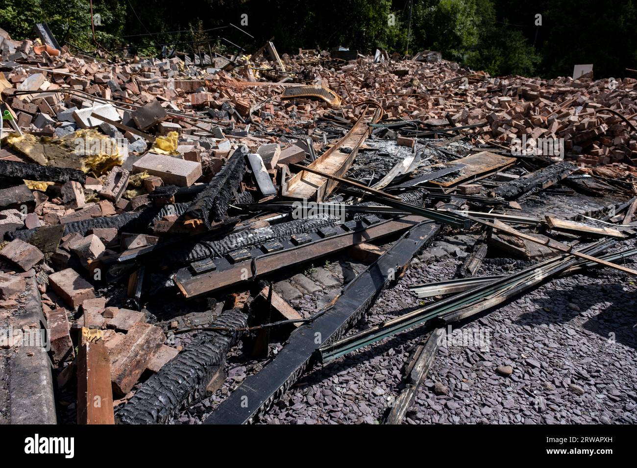 Überreste des Crooked House Pub in Himley, wo am Wochenende unter unerklärlichen Umständen ein Brand ausbrach und der weniger als zwei Tage später unerwartet abgerissen wurde, was die Einheimischen am 11. August 2023 in der Nähe von Dudley, Großbritannien, verärgerte. Die Polizei untersucht die Umstände des Brandes als Brandstiftung und versucht festzustellen, ob der Abriss rechtmäßig war. Das charakteristische Erscheinungsbild des Crooked House war das Ergebnis einer Absenkung des Bergbaus, die dazu führte, dass die eine Seite des Gebäudes etwa 1,2 m niedriger war als die andere. Es war bekannt als „Britains Wonkiest Pub“ und optische Illusionen ins Stockfoto