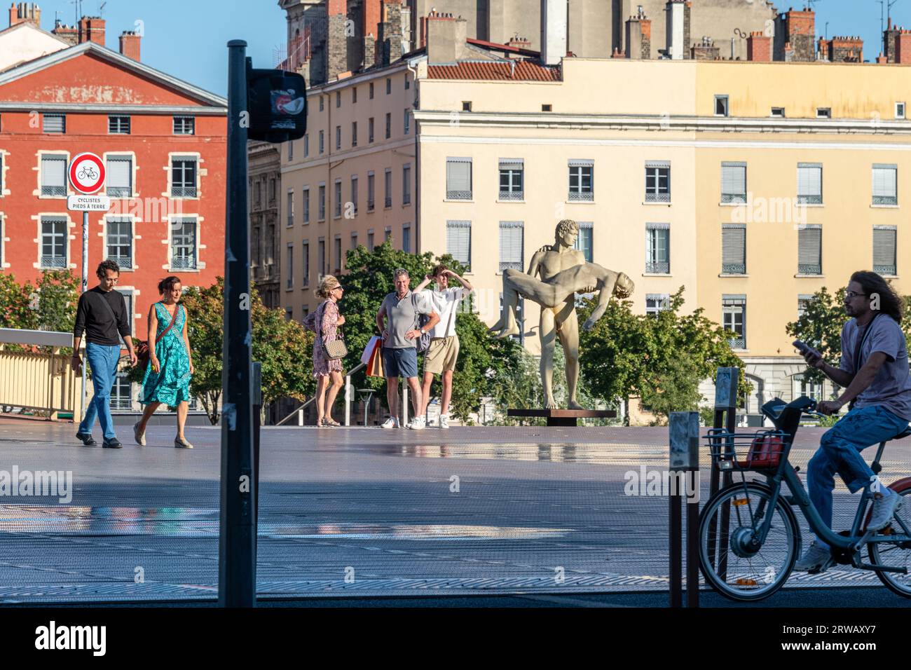 Touristen versammeln sich neben der Statue „das Gewicht eines selbst“ am Ufer der Saone in Lyon, Frankreich. Stockfoto