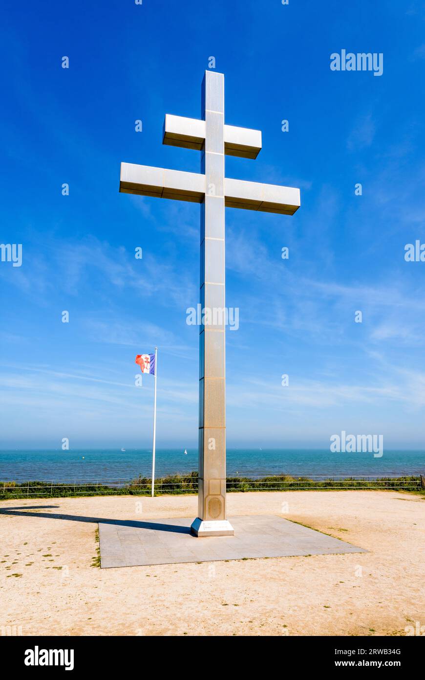 Großes Kreuz von Lothringen vor der Flagge von Free France, das 1990 am Juno Beach errichtet wurde, um an die Rückkehr von General de Gaulle nach Frankreich im Jahr 1944 zu erinnern. Stockfoto