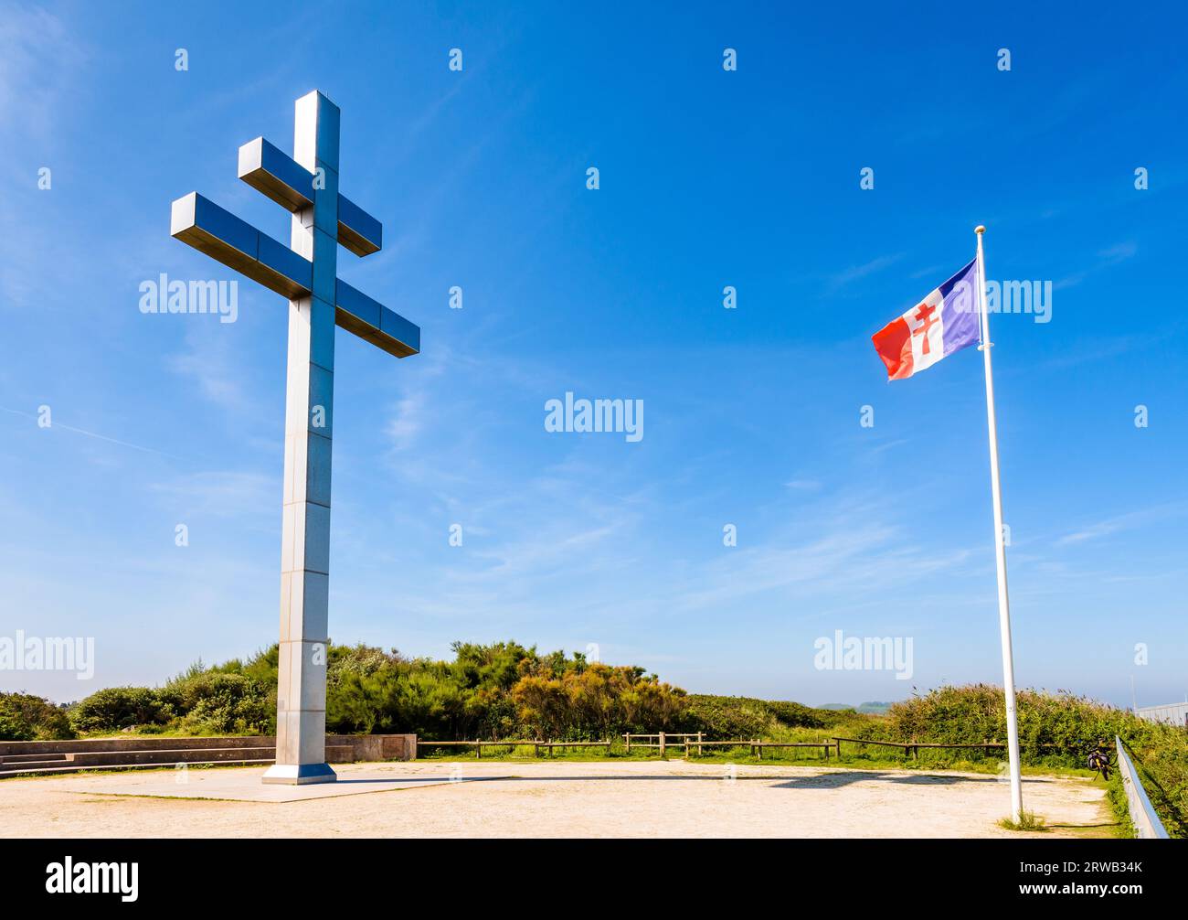 Großes Kreuz von Lothringen vor der Flagge von Free France, das 1990 am Juno Beach errichtet wurde, um an die Rückkehr von General de Gaulle nach Frankreich im Jahr 1944 zu erinnern. Stockfoto
