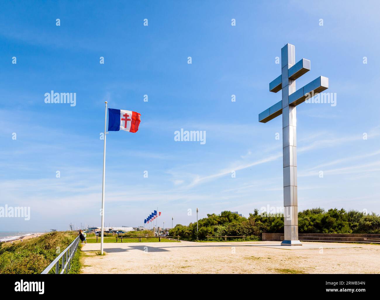 Großes Kreuz von Lothringen vor der Flagge von Free France, das 1990 am Juno Beach errichtet wurde, um an die Rückkehr von General de Gaulle nach Frankreich im Jahr 1944 zu erinnern. Stockfoto