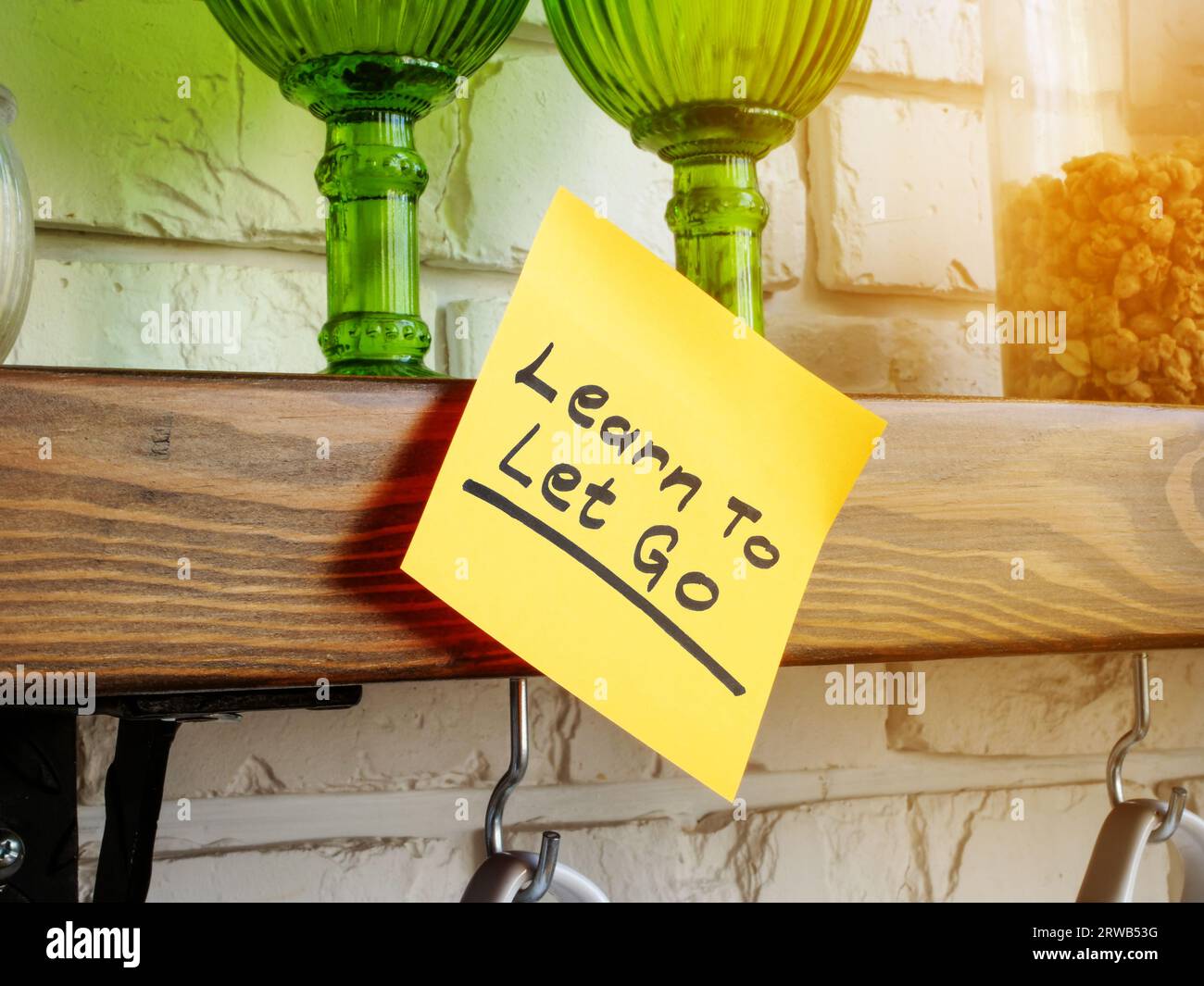 Der Aufkleber mit der Aufschrift Learn to let Go ist an Ihrem Regal befestigt. Stockfoto