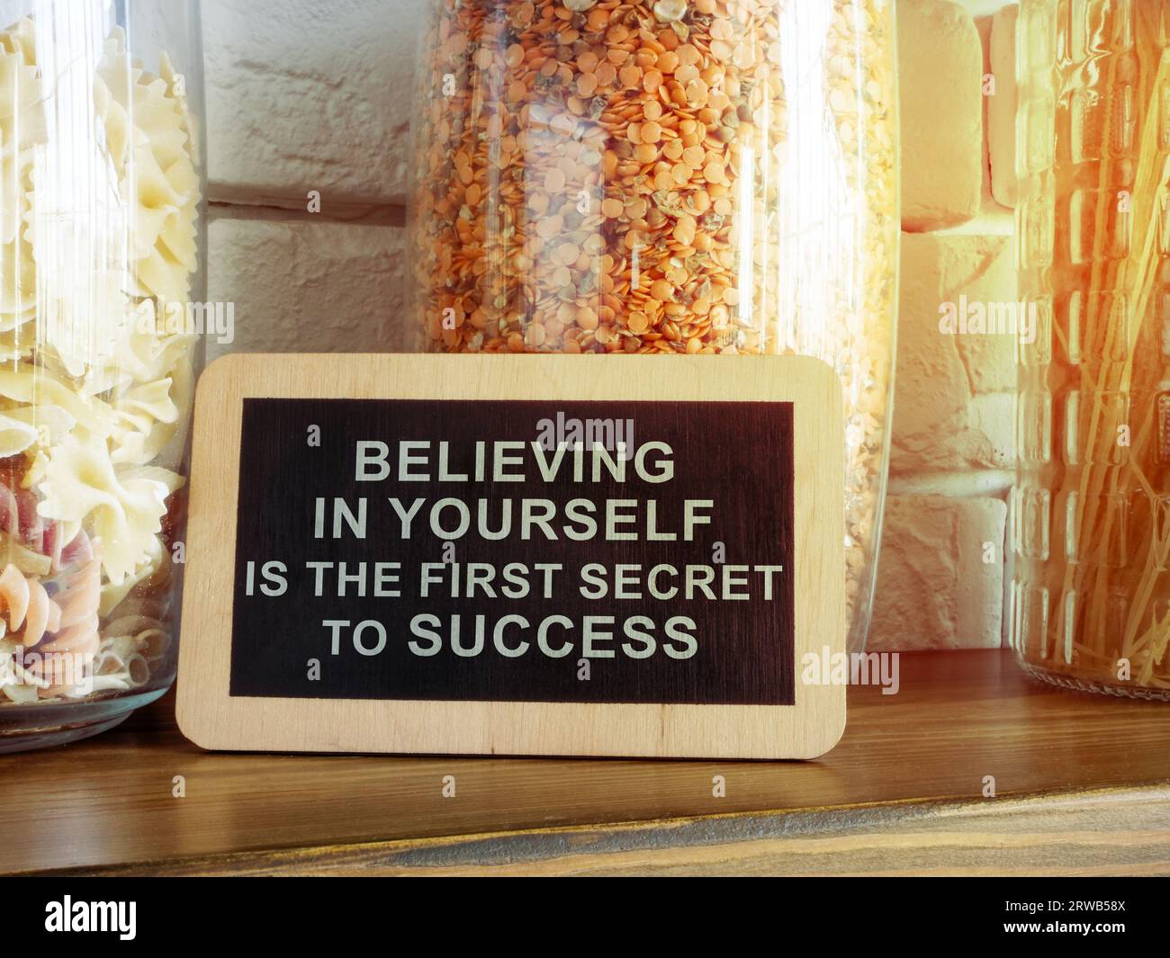 Zeichen mit einer Inschrift Glauben an sich selbst ist das erste Erfolgsgeheimnis auf dem Küchenregal. Stockfoto