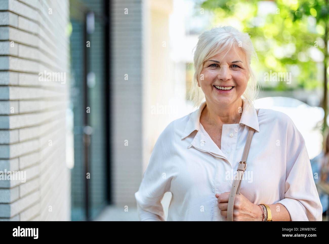 Porträt einer glücklichen Seniorin, die in der Stadt steht Stockfoto