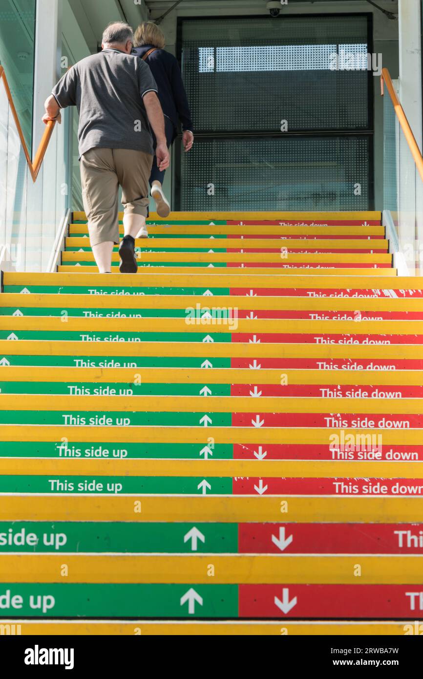 Diese Seite nach oben, diese Seite nach unten, rote und grüne farbige Treppenschilder am Bahnhof Clapham Junction, London, England, Großbritannien Stockfoto