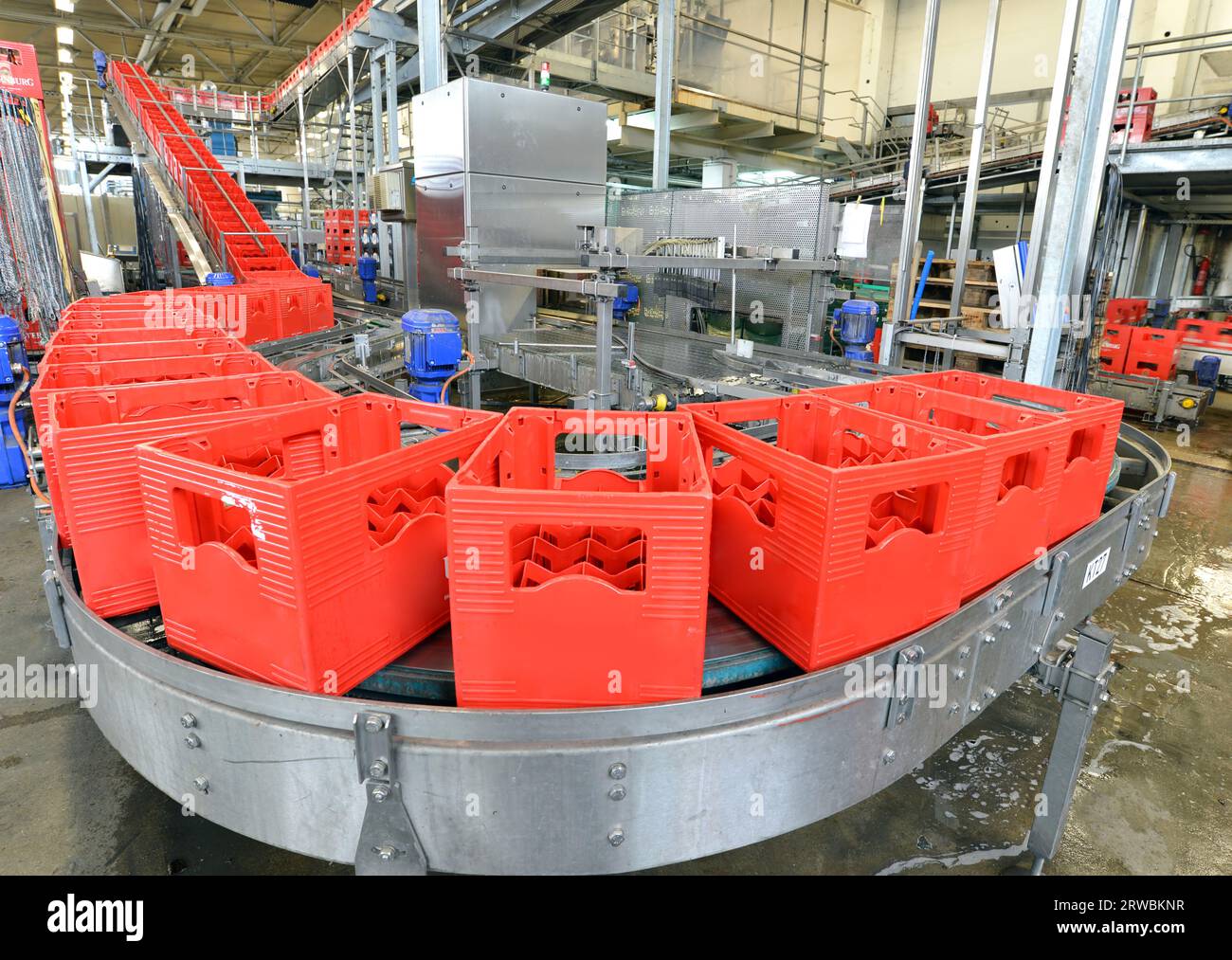 Moderne Fabrik in der Lebensmittelindustrie - Bier Brauerei - Transportband mit Bierflaschen und Maschinen für die Produktion Stockfoto