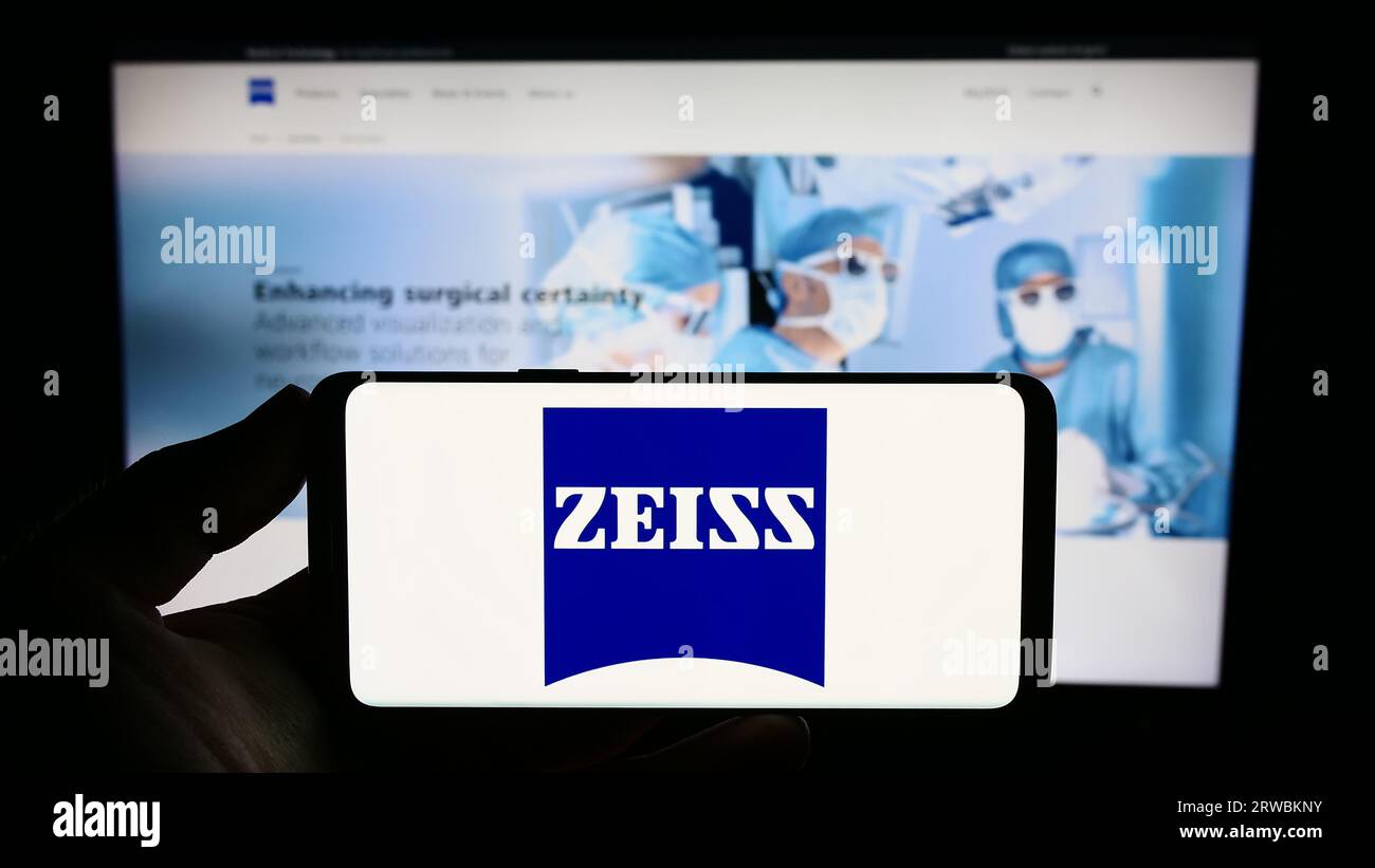 Person mit Smartphone mit Logo des Medizintechnikunternehmens Carl Zeiss Meditec AG auf dem Bildschirm vor der Website. Konzentrieren Sie sich auf das Display des Telefons. Stockfoto