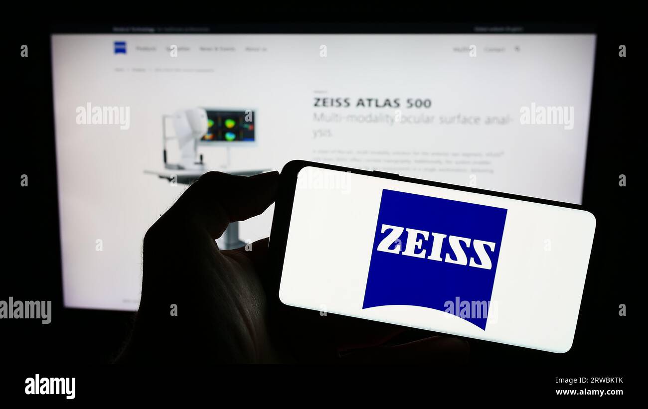 Person, die Handy mit Logo des Medizintechnikunternehmens Carl Zeiss Meditec AG auf dem Bildschirm vor der Webseite hält. Konzentrieren Sie sich auf das Display des Telefons. Stockfoto