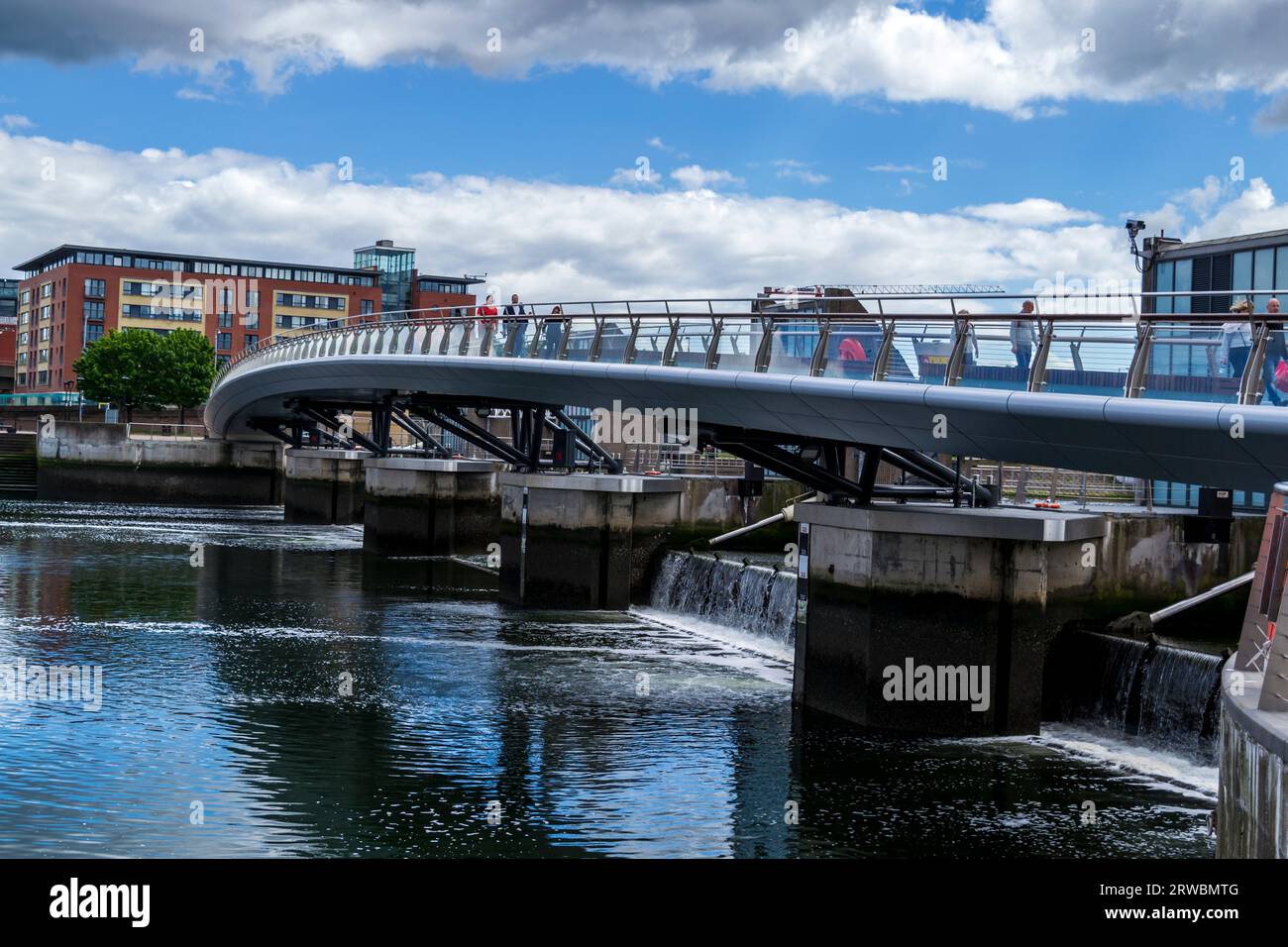 Belfast County Antrim Nordirland 3. Juni 2017 - Menschen, die über die kurvige Lagan Weir-Fußbrücke über das Lagan Weir in Belfast laufen Stockfoto