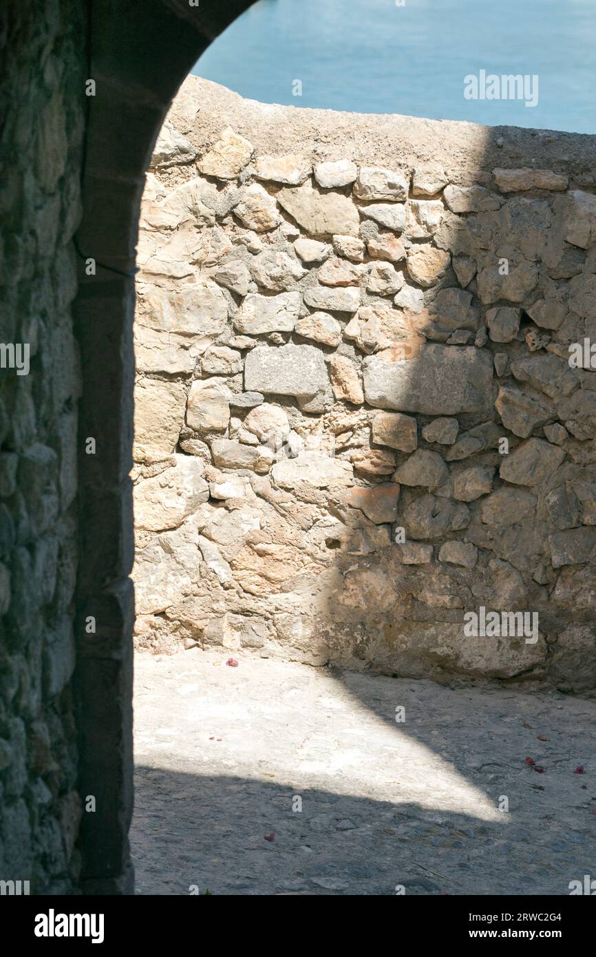 Ein abstrakter Schatten fällt auf eine Steinmauer in einer Seitenstraße von Eivissa, Ibiza Altstadt, Balearen, Ibiza, Spanien Stockfoto