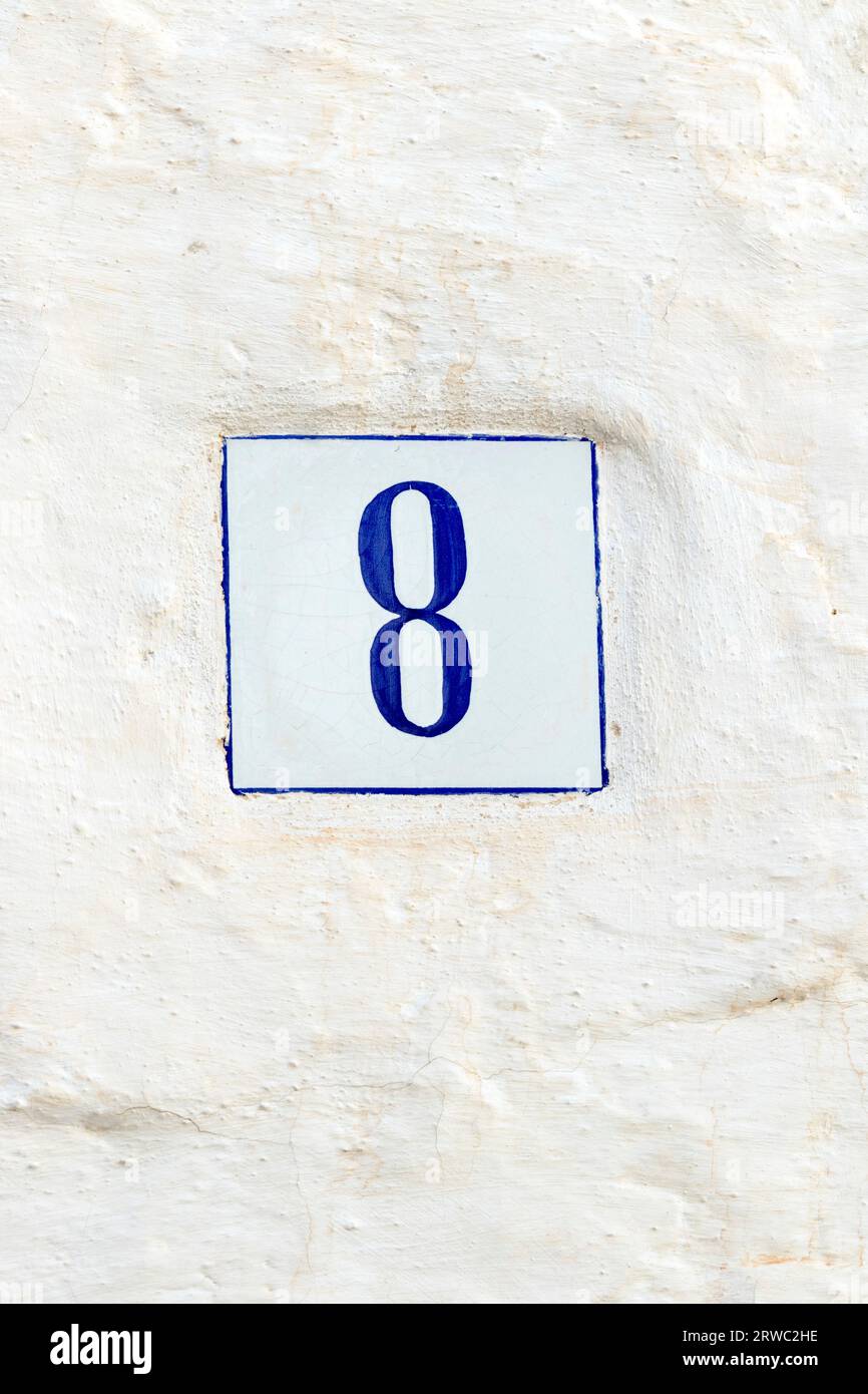 Blaue Hausnummer 8 an einer weißen Wand Stockfoto