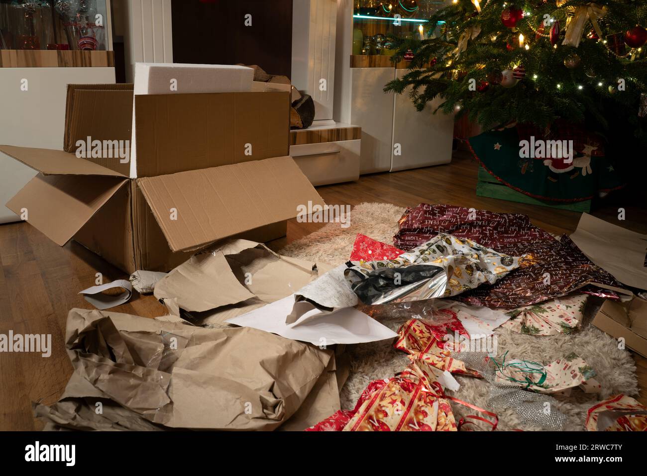 Es ist Heiligabend. Die Geschenke wurden ausgepackt. Im weihnachtlichen Wohnzimmer herrscht ein Chaos aus Geschenkpapier und Boxen unter der Weihnachts-tr Stockfoto