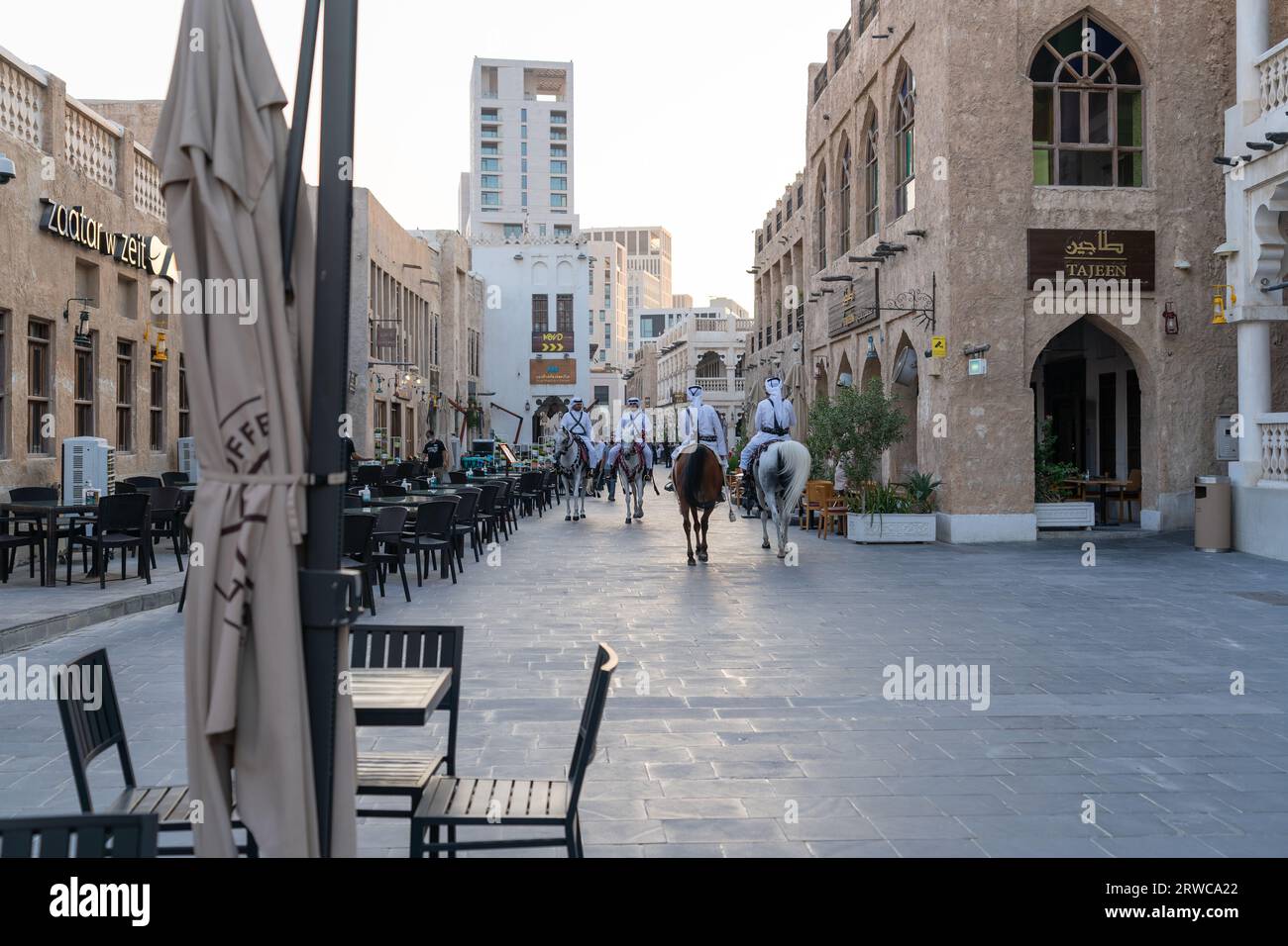 Doha, Katar - 17. Oktober 2022: Touristenpolizisten in traditioneller katarischer Kleidung patrouillieren auf dem Fußweg im Souq Wakif. Stockfoto