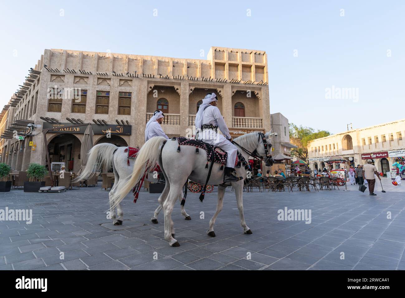 Doha, Katar - 17. Oktober 2022: Touristenpolizisten in traditioneller katarischer Kleidung patrouillieren auf dem Fußweg im Souq Wakif. Stockfoto