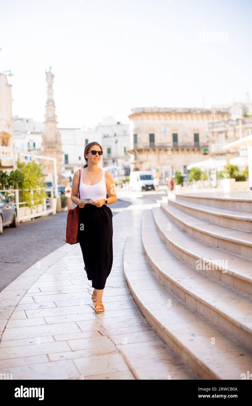 Weibliche Touristen mit einem Stadtplan von der Statue des Heiligen Oronzo in Ostuni, Italien Stockfoto