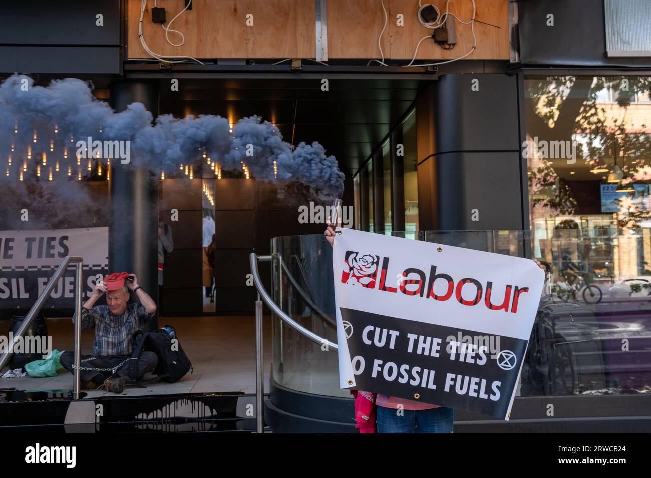 Mitglieder der Extinction Rebellion Poor Oil On, Ketten sich an und klettern den Eingang zum Hauptquartier der Labour Party an. Stockfoto