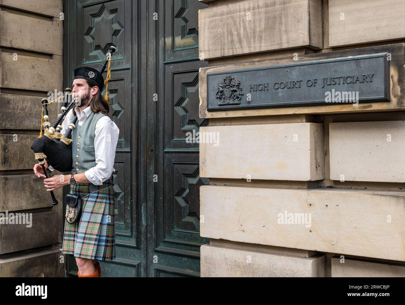 Dudelsack-Spielkleidung Kilt-Busking vor dem High Court of Justiciary, Royal Mile, Edinburgh, Schottland, Großbritannien Stockfoto