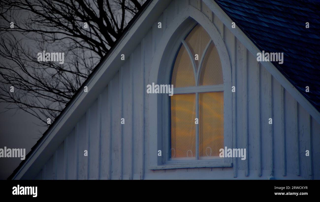 Der Sonnenuntergang im Winter spiegelt sich in einer detaillierten Perspektive des berühmten gotischen Fensters des berühmten American Gothic House wider. Stockfoto