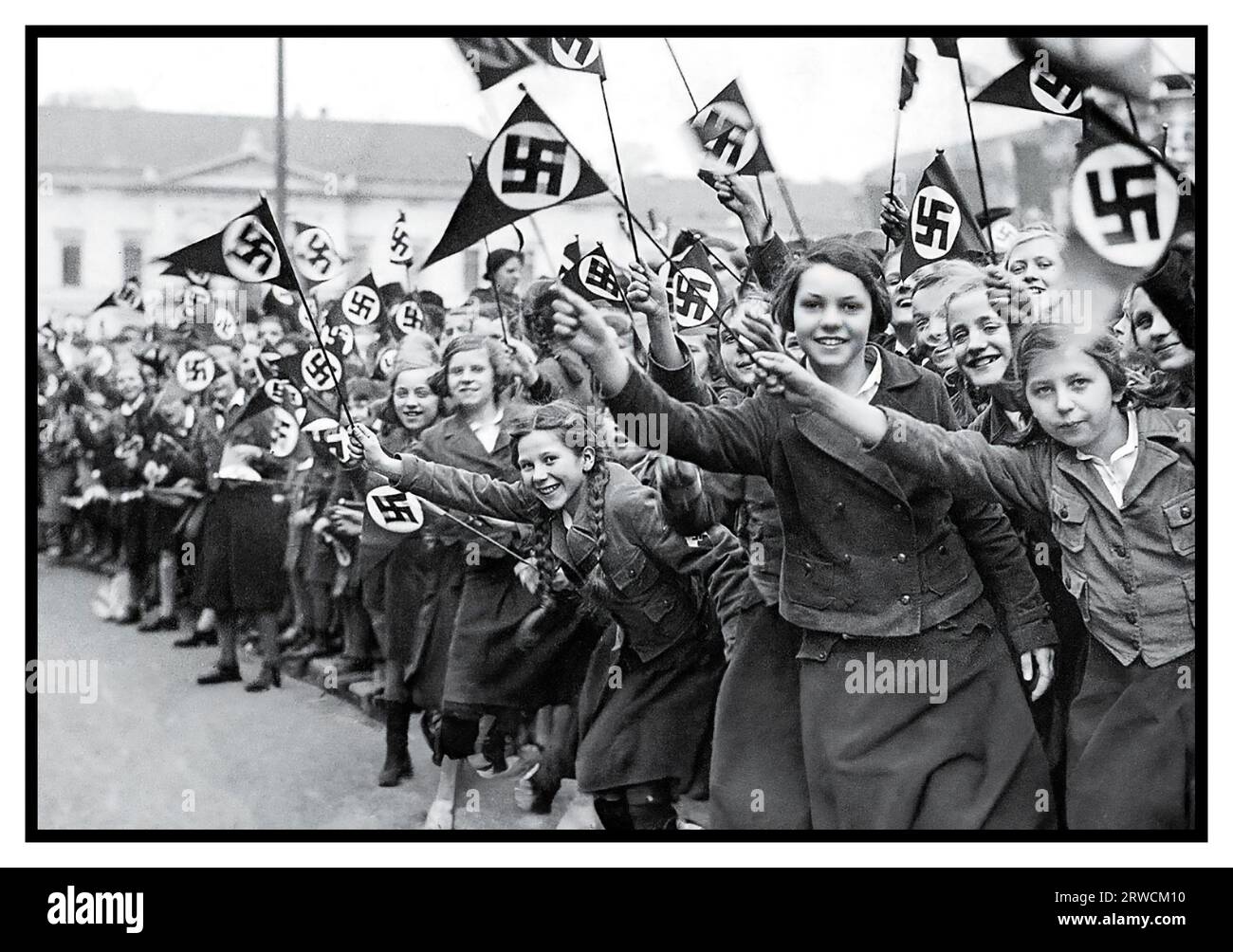 Der Deutsche Mädchenbund von Anschluss 1930 schwenkt Nazi-Hakenkreuz-Fahnen, um die deutsche Annexion Österreichs zu unterstützen und zu beglückwünschen. Wien, Österreich, März 1938. Am 14. März 1938 trat die Armee des NS-Führers Adolf Hitler in die Stadtgrenzen Wiens ein, um Austria Anschluss anzubauen Stockfoto