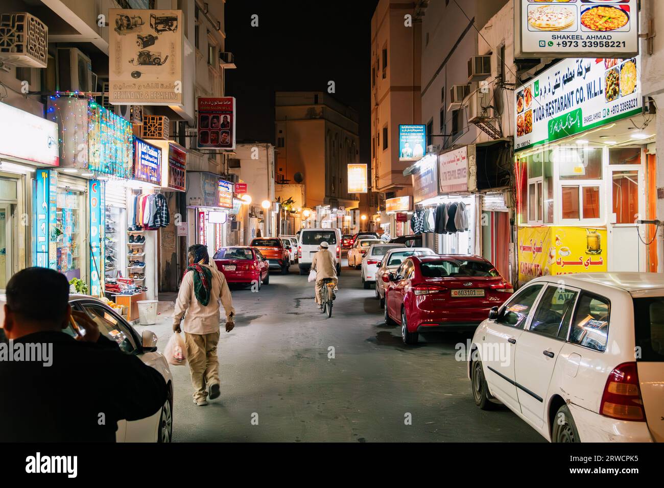 Restaurant- und Shoppingbeleuchtung beleuchten eine Straße in Al Muharraq, einem alten Viertel in Manama, der Hauptstadt von Bahrain Stockfoto