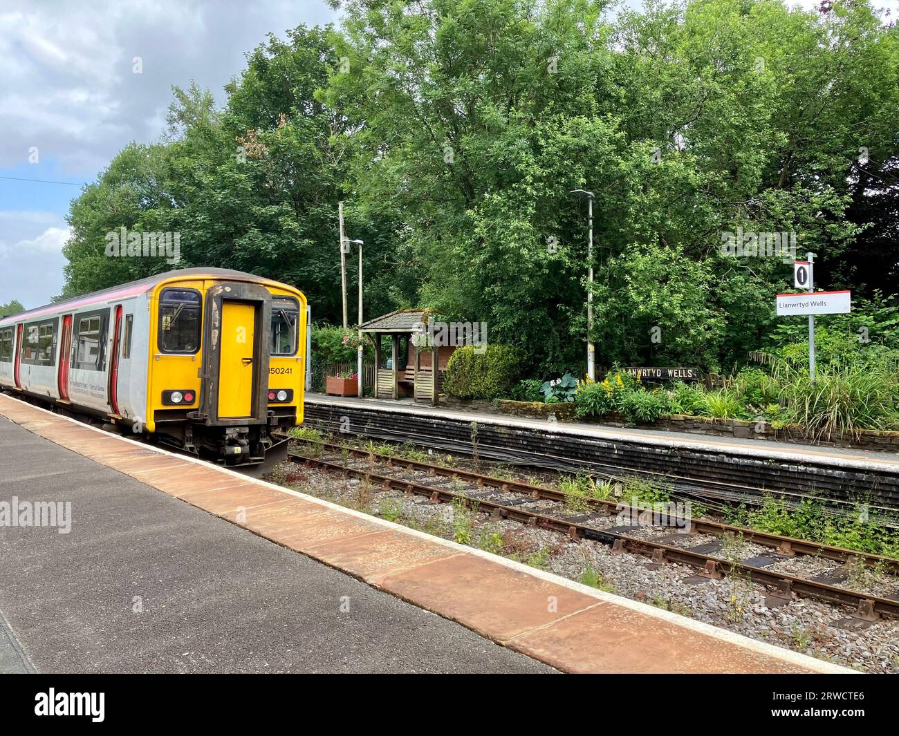 Dieselzug der Klasse 150 nähert sich dem Bahnsteig Llanwrtyd Wells Station, im Herzen der Wales Line, Powys, Wales, Großbritannien Stockfoto