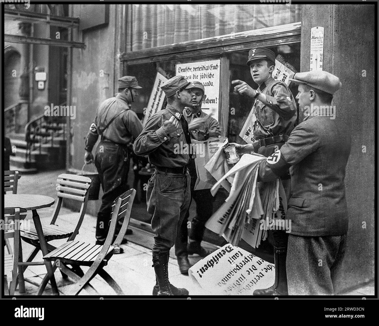 BOYKOTT von jüdischen Geschäften in den 1930er Jahren mit paramilitärischen uniformierten Vollstreckern der Sturmabteilung, die Hakenkreuz-Armbänder tragen, um ein jüdisches Verbot des Boykotts zu gewährleisten, indem antijüdische antisemitische Plakate in Berlin-Nazideutschland veröffentlicht werden Stockfoto