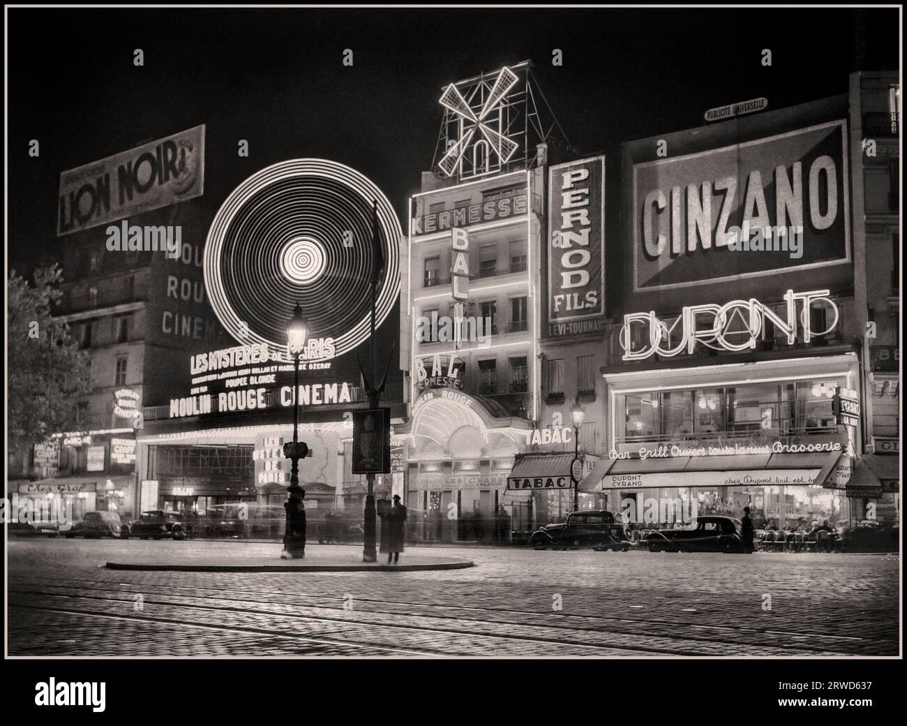 Retro Vintage Paris B&W 1930's The Moulin Rouge The Boulevard de Clichy Historic Montmartre Paris France at Night Alcohol Drinks Advertising Hoardings, Cinzano, Pernod, DuPont. Lion Noir. 1936: Frankreich, Paris Moulin Rouge Fotograf: Willem van de Poll Stockfoto