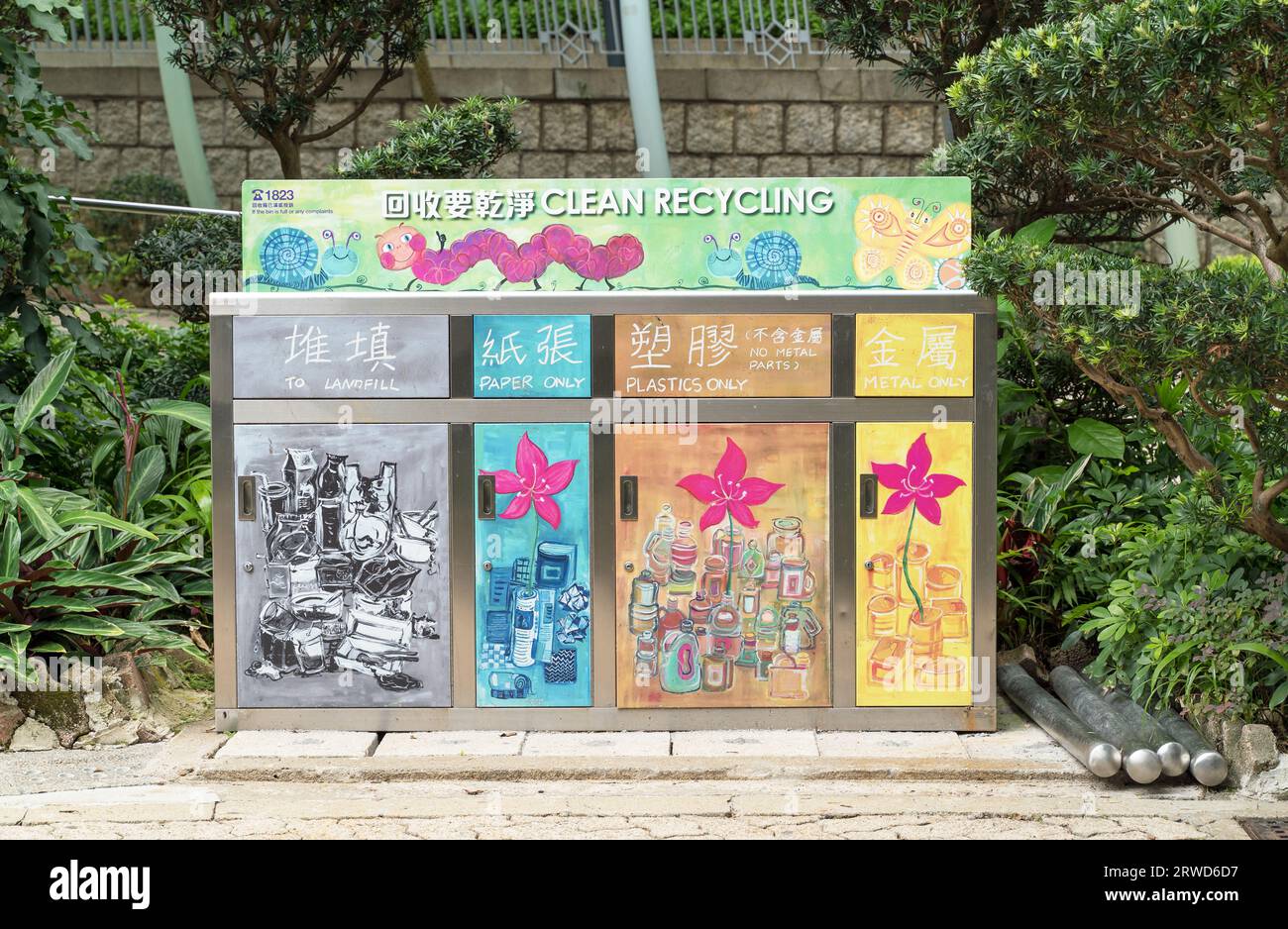 Recyclingbehälter für Papier, Kunststoffe und Metall im Central Park von Hongkong, umgeben von Pflanzen. Hongkong - 31. August 2023 Stockfoto
