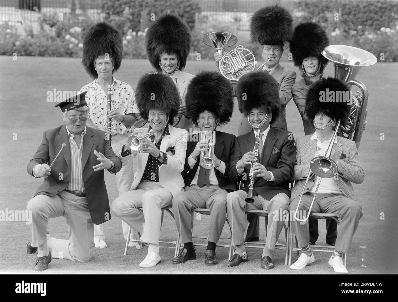 LONDON, GROSSBRITANNIEN. 1. September 1986: Comedian Benny Hill dirigiert seine Mitmusiker George Layton (oben links), Nick Owen, Eamonn Andrews, Jim Davidson, Lionel Blair, Richard Briers, Bernie Winters und George Cole bei der Thames TV Garden Party in London. Datei Foto © Paul Smith/Featureflash Stockfoto