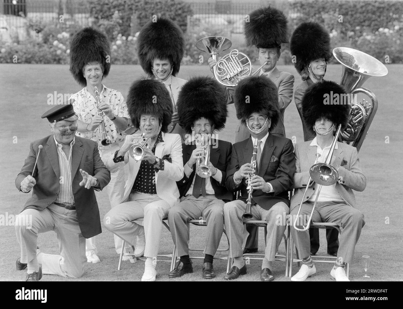 LONDON, GROSSBRITANNIEN. 1. September 1986: Comedian Benny Hill dirigiert seine Mitmusiker George Layton (oben links), Nick Owen, Eamonn Andrews, Jim Davidson, Lionel Blair, Richard Briers, Bernie Winters und George Cole bei der Thames TV Garden Party in London. Datei Foto © Paul Smith/Featureflash Stockfoto