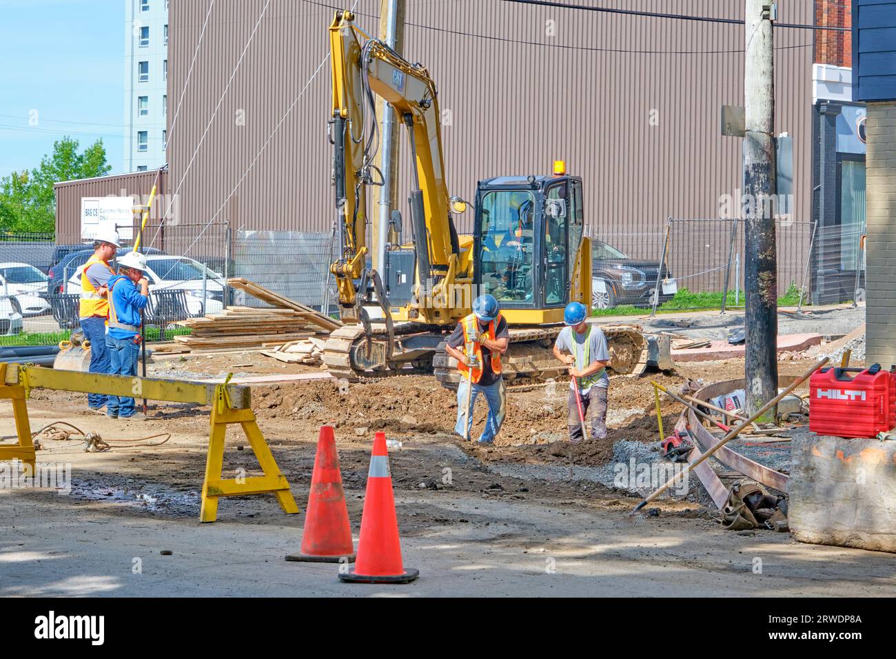 Arbeiter installieren neue Wasserleitungen an einer Straße in der Innenstadt. Stockfoto