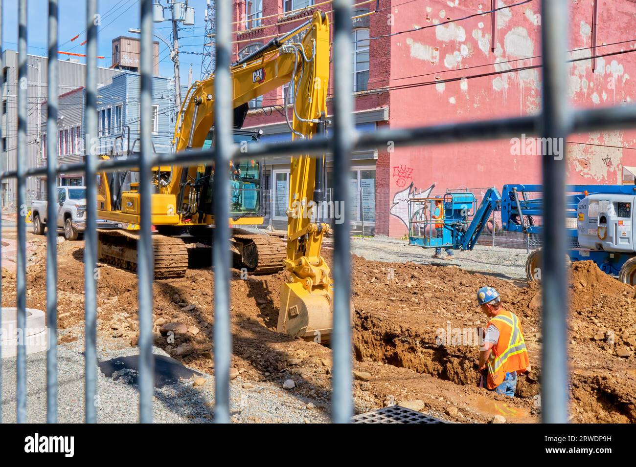 Arbeiter installieren neue Wasserleitungen an einer Straße in der Innenstadt. Stockfoto