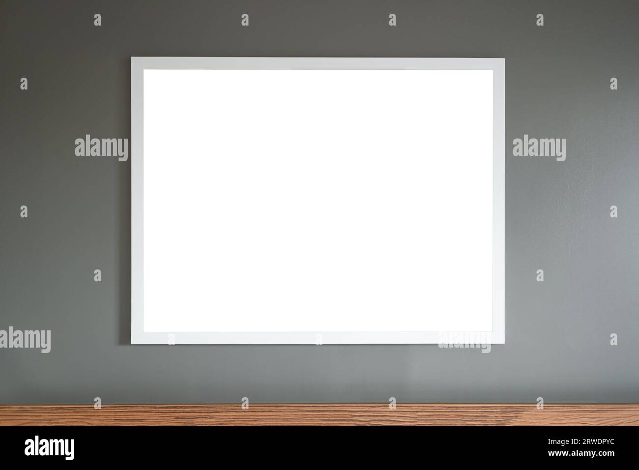 Weißes Rahmenbrett, das an der grauen Wandvorlage hängt, leeres mittiges Holzelement darunter Stockfoto