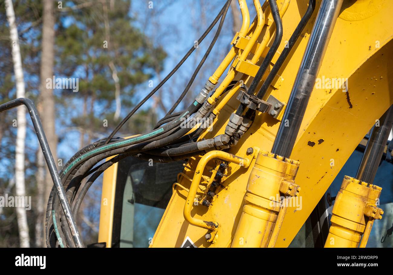 Schließen der Hydraulikschläuche, -Rohre, -Armaturen und -Zylinder an einer funktionierenden Baggermaschine. Stockfoto