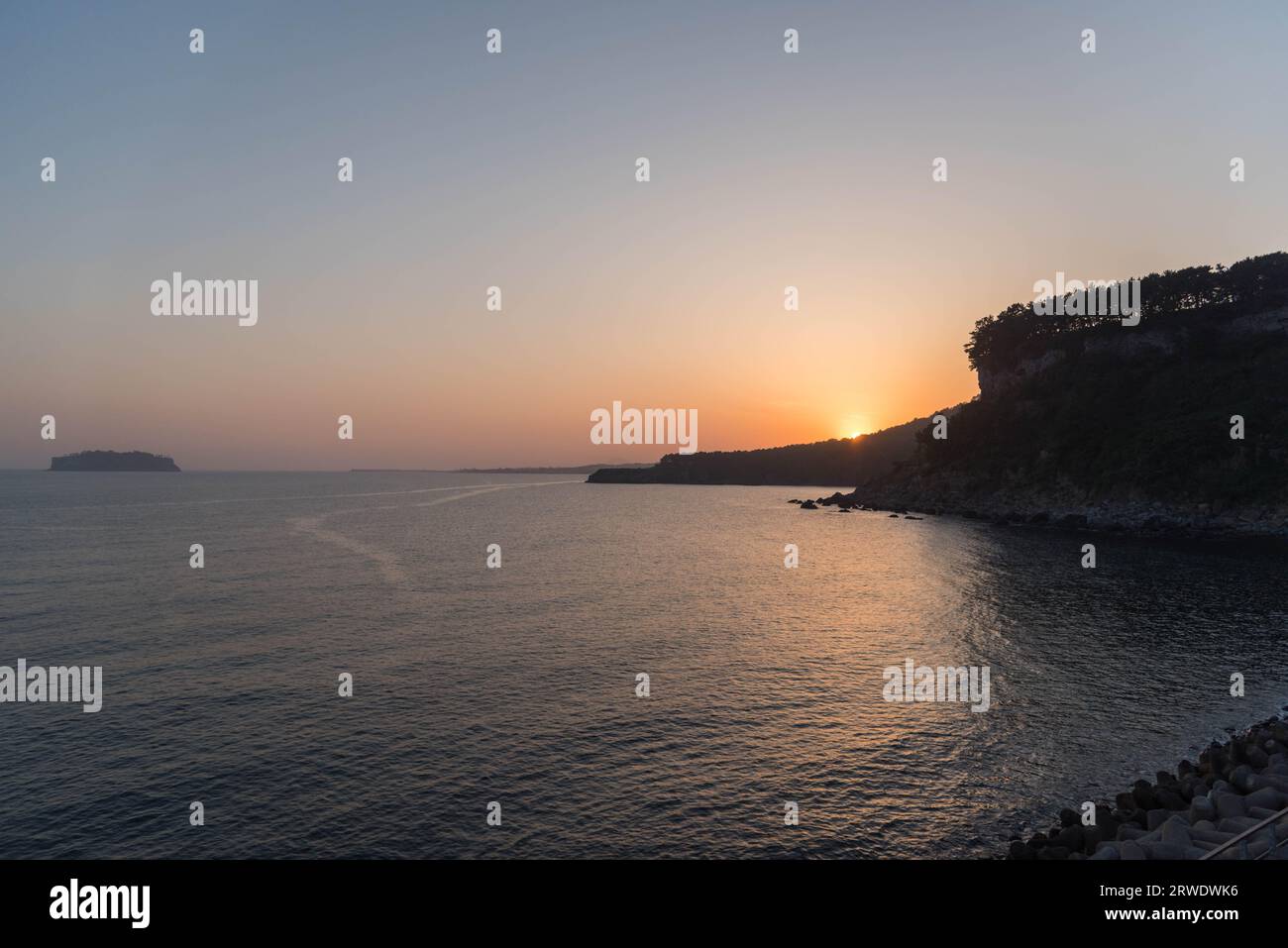 Sonnenuntergang am Meer, mit dem Sonnenuntergang hinter dem Felsen, aufgenommen auf Jeju Island, Südkorea. Stockfoto