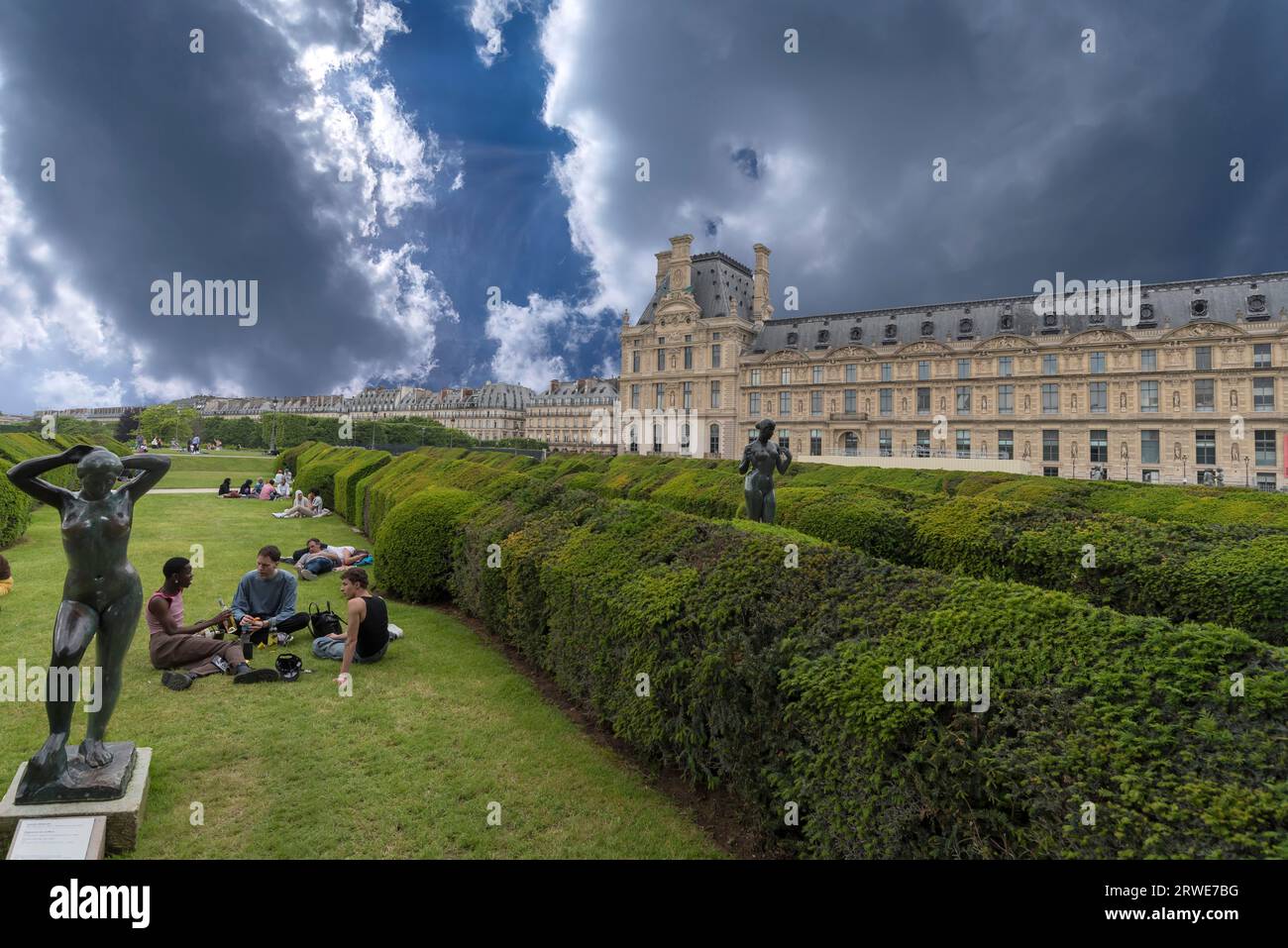 Junge Menschen auf den Grünflächen vor dem Louvre, Paris, Frankreich Stockfoto