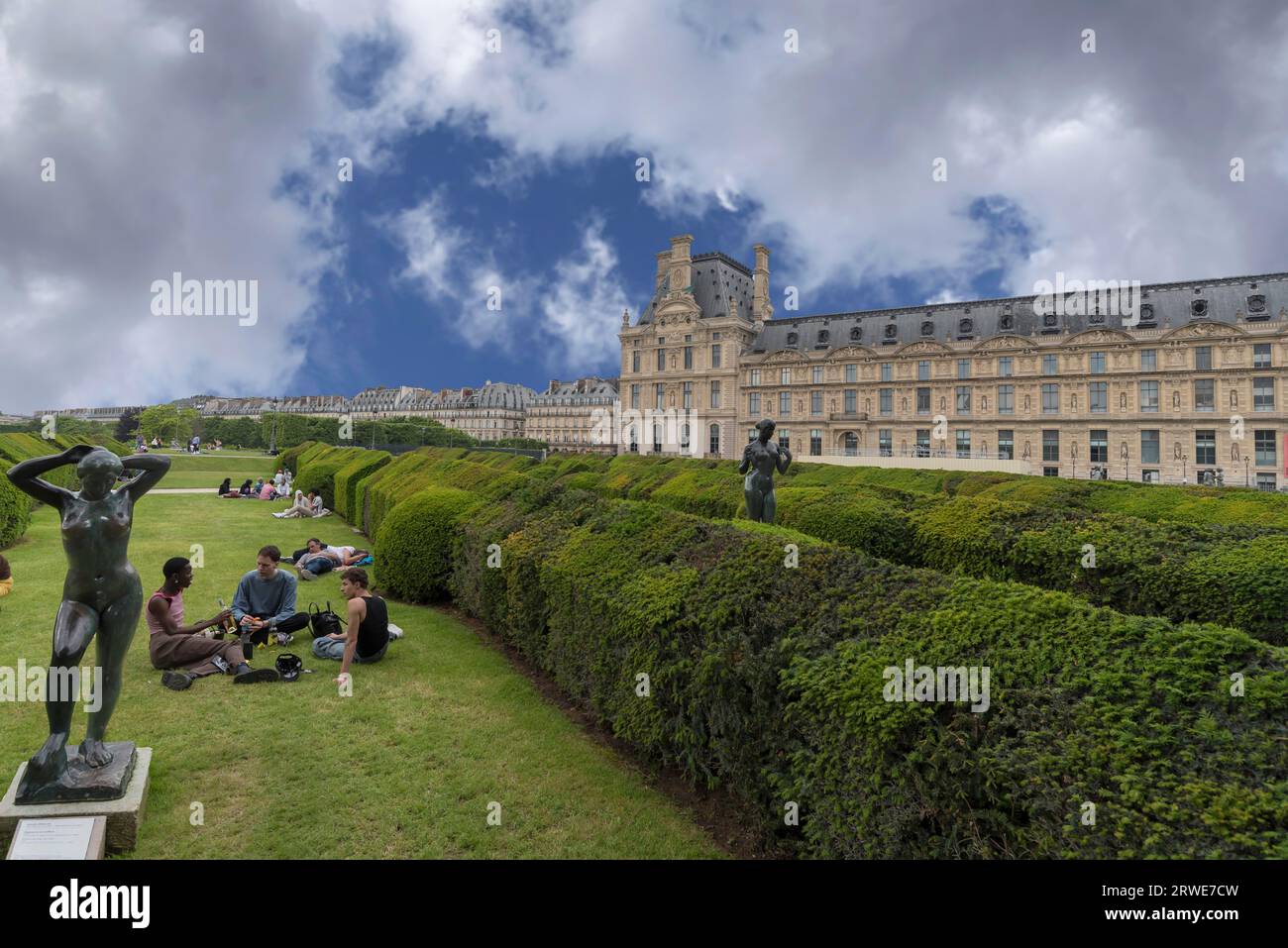 Junge Menschen auf den Grünflächen vor dem Louvre, Paris, Frankreich Stockfoto