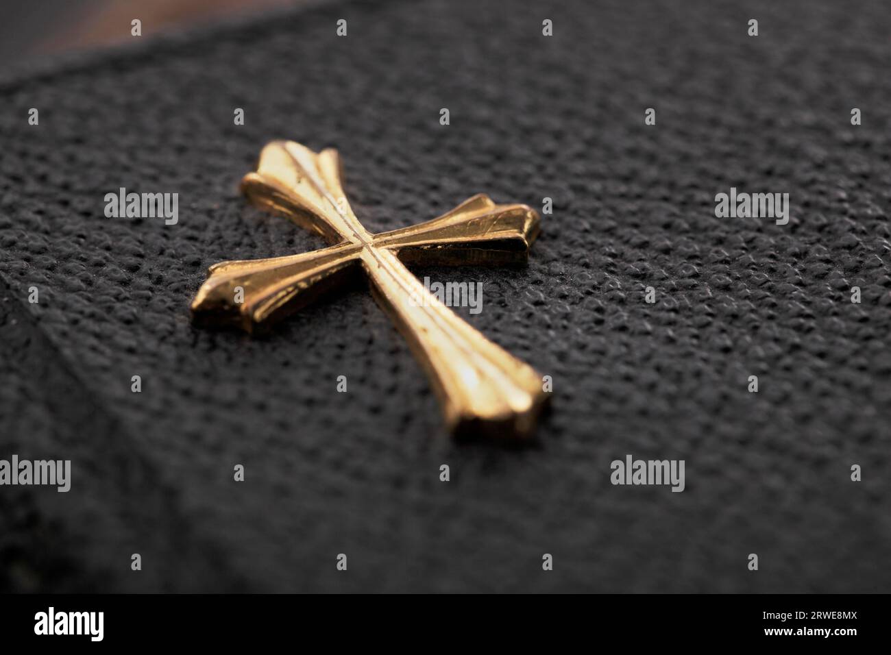Goldenes Kreuz auf dem Cover einer alten Bibel im Taschenformat Stockfoto