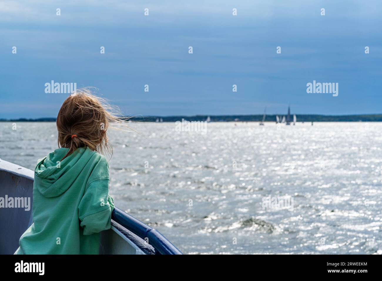 Mädchen auf einem Ausflugsboot mit Blick auf Segelschiffe auf der Ostsee, Greifswalder OIE, Usedom Island, Mecklenburg-Vorpommern, Deutschland Stockfoto