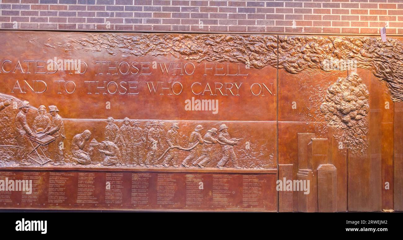 New York, USA, 3. Dezember 2011: May We Never Forget, geschrieben auf der bronzenen Basreliefmauer der FDNY Ten House Fire Station Stockfoto